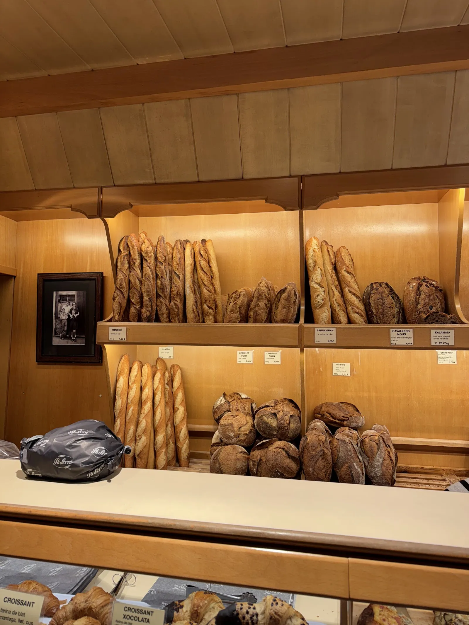 L'interior de la botiga, amb barres i pans rodons als prestatges de fusta