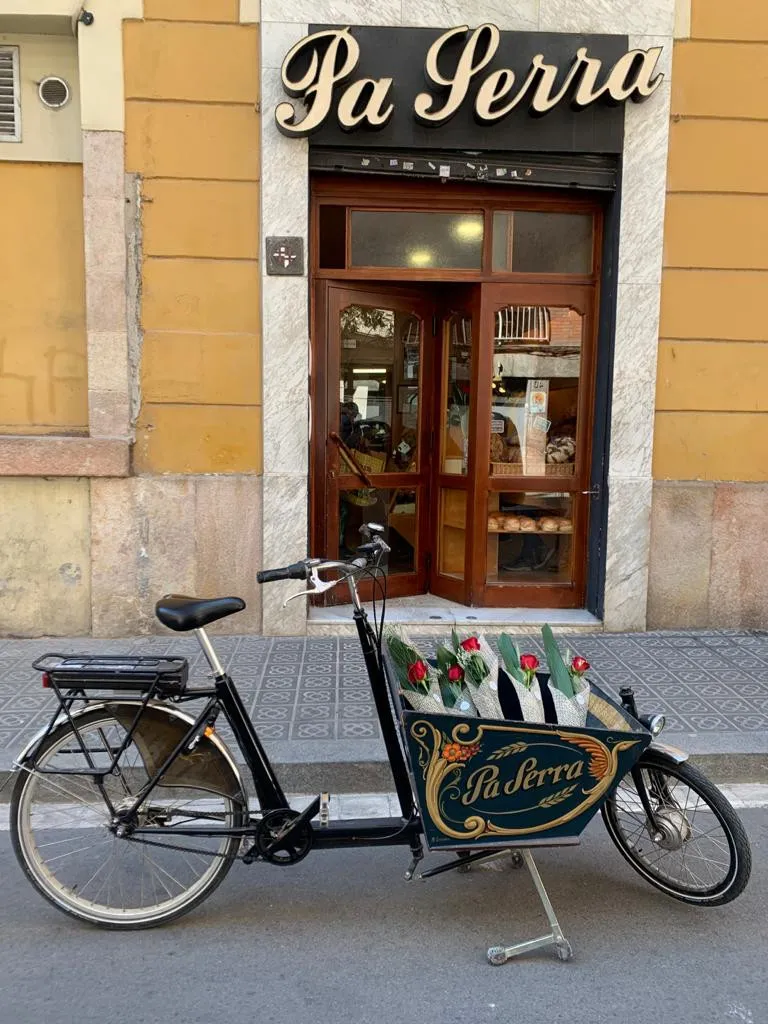 La façana del Forn Pa Serra des del carrer, amb una bicicleta de càrrega al davant